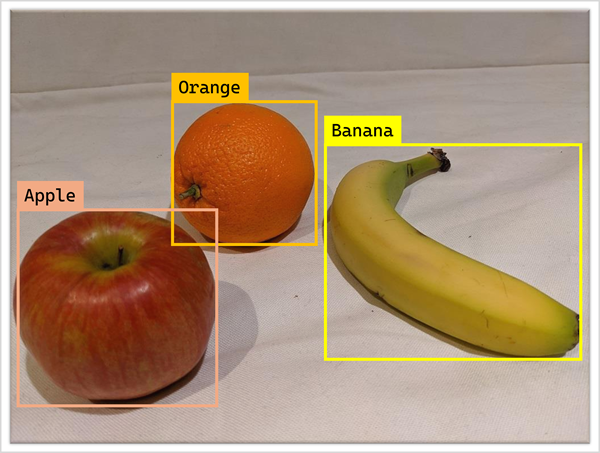 Fotografia di un'arancia, una mela e una banana con rettangoli delimitatori.